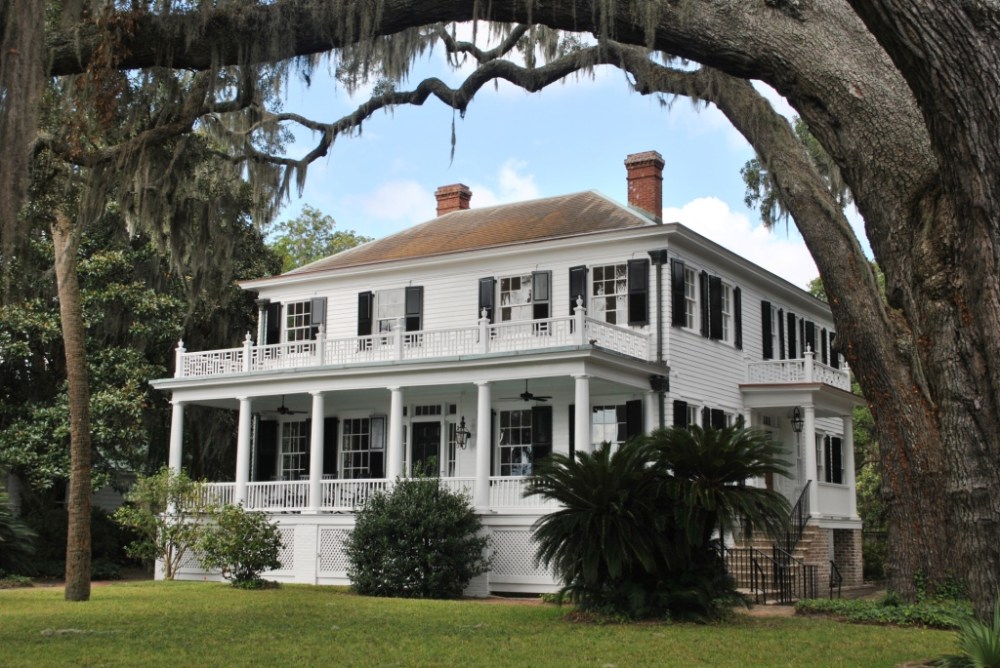 a tree in front of a house with Ralph Waldo Emerson House in the background